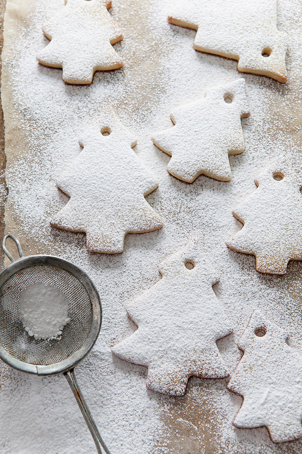 Seven Tree Shaped Biscuits Dusted In Icing Sugar From A Vinatge Mini Sifter On Brown Baking Paper Photograph by Stacy Grant