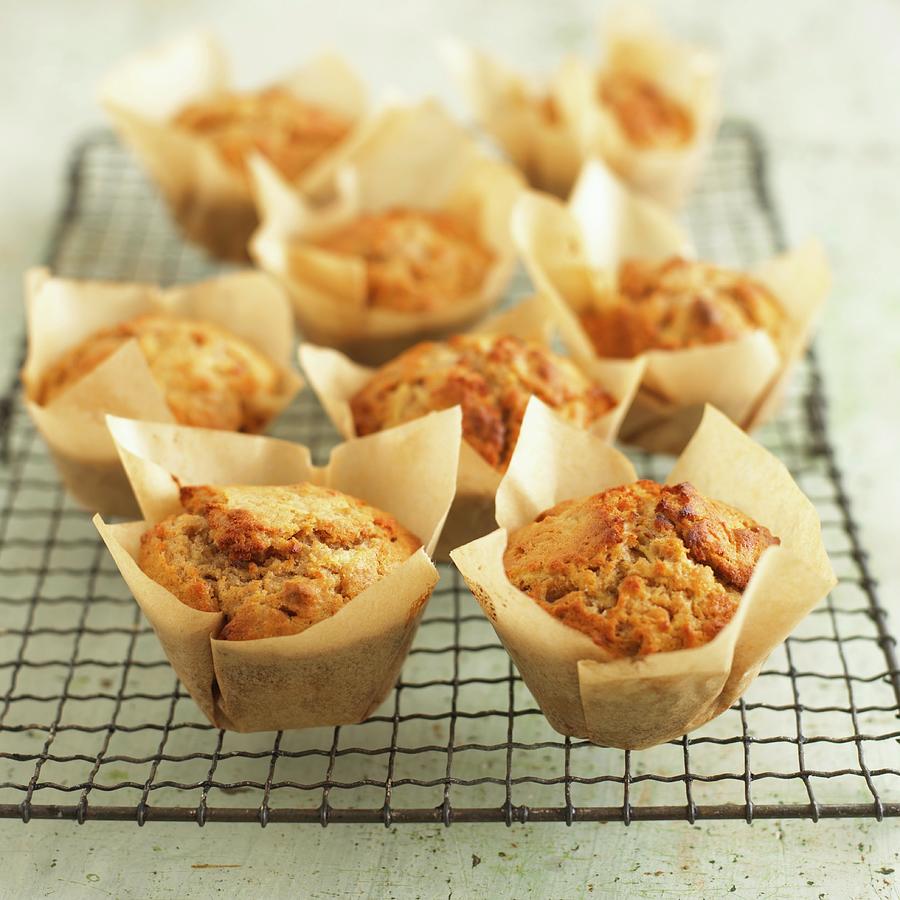 Several Apple & Walnut Muffins In Baking Parchment On A Wire Rack Photograph by Dave King