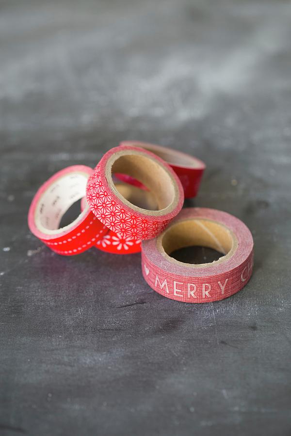 Several Rolls Of Red, Patterned Washi Tape On Grey Surface Photograph by Tina Engel