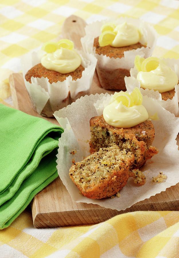 Several Seeded Lemon Drizzle Cupcakes In White Paper Cupcake Cases On A Wooden Board Photograph by Stuart Macgregor