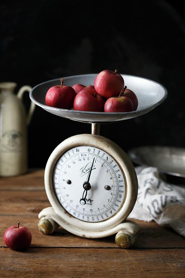 Several Small Red Apples On An Old Kitchen Scale Photograph by Mona Binner Photographie