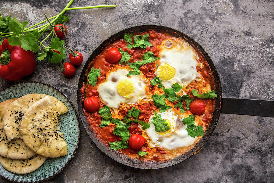 Shakshuka In An Iron Pan With Pita Bread, Paprika, Tomatoes And Parsley Photograph by Sandra Rsch
