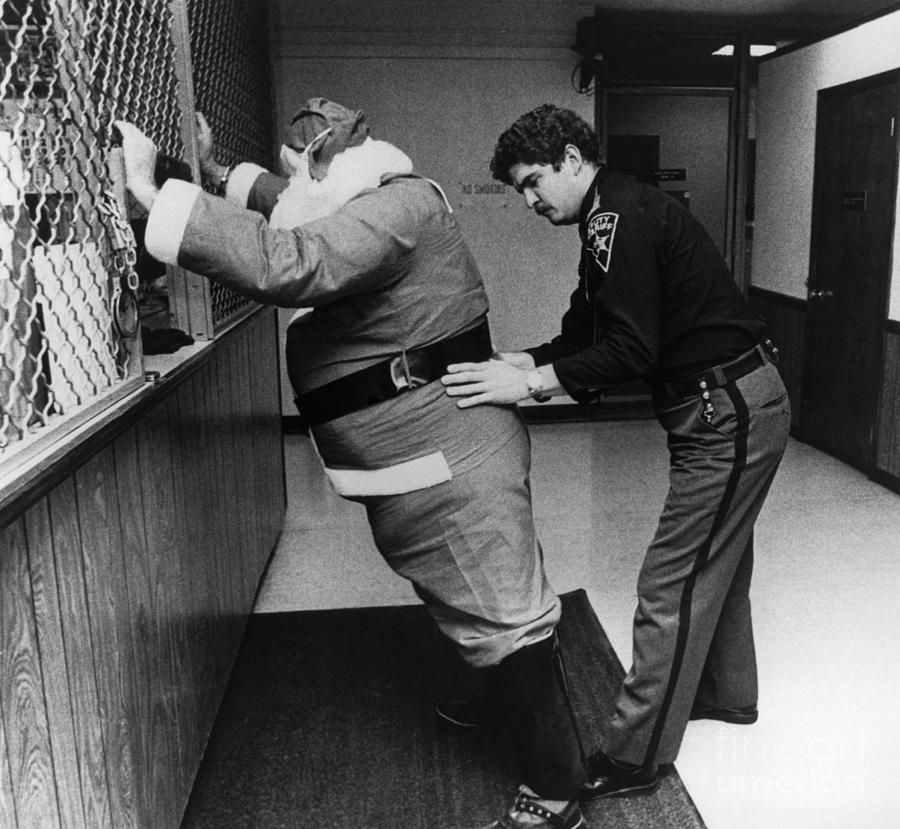 Sheriff Frisking Santa Claus Photograph by Bettmann