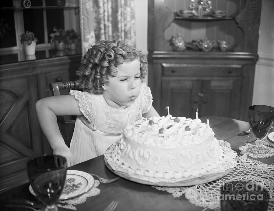 Shirley Temple Blowing Out Candles Photograph by Bettmann