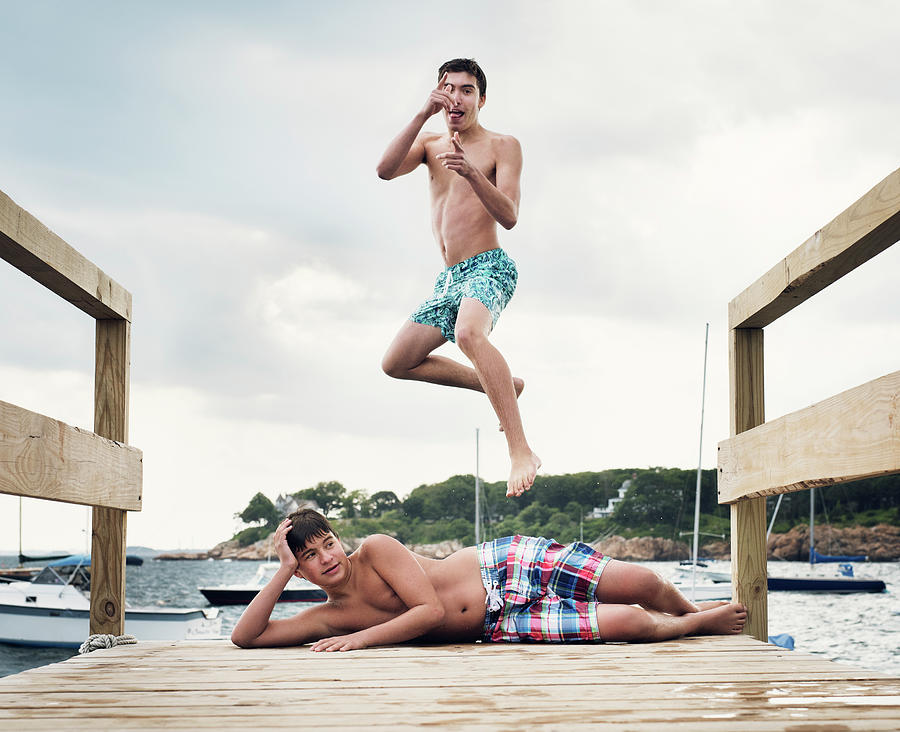 Nature Photograph - Shirtless Brothers Enjoying At Pier Over Sea Against Sky by Cavan Images
