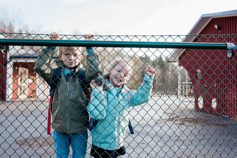 Parenthood Movie Photograph - Siblings Looking Through A School Fence Smiling At Their Dad by Cavan Images