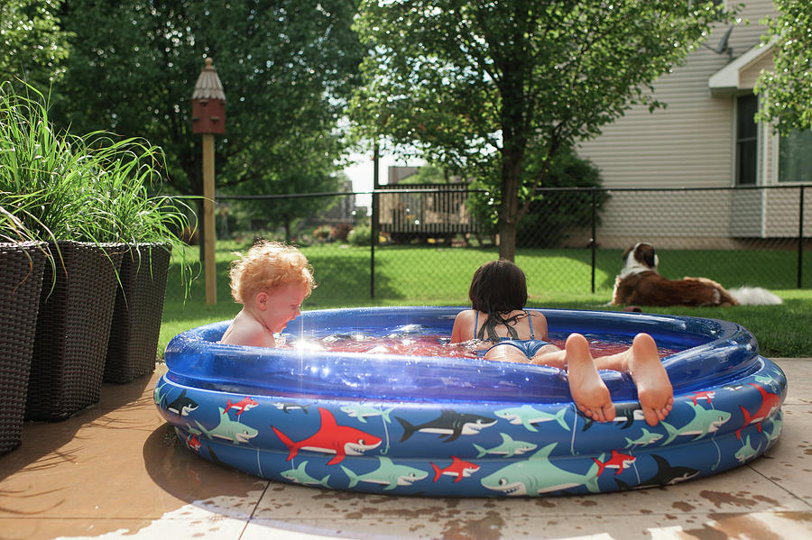 Siblings Swimming In Wading Pool At Yard Photograph by Cavan Images ...