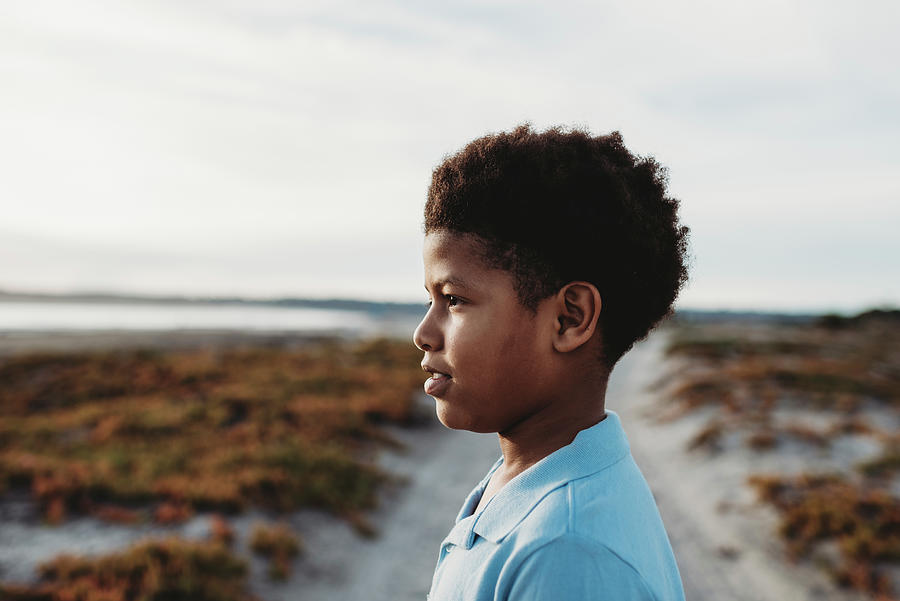 Side View Close Up Serious Portrait Of Young School Age Boy At Beach ...