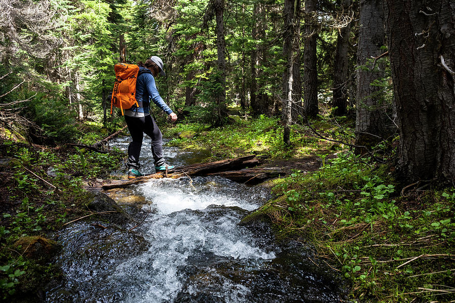 Side View Of Unrecognizable Hiker With Backpack Crossing Narrow Fast 