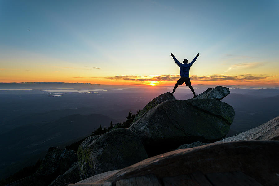 Silhouette Man With Arms Raised Standing On Rocks Against Sky At Mount 