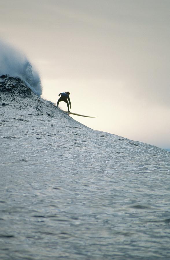 Silhouette Of A Surfer Riding A Wave Photograph by Dominic Barnardt