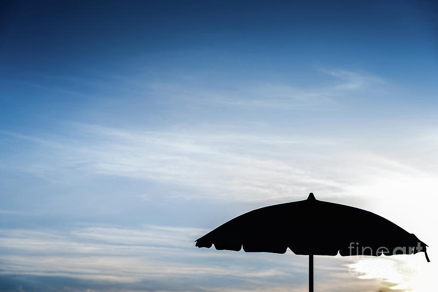 Silhouette of beach umbrella against backlight on a hot summer d Photograph by Joaquin Corbalan