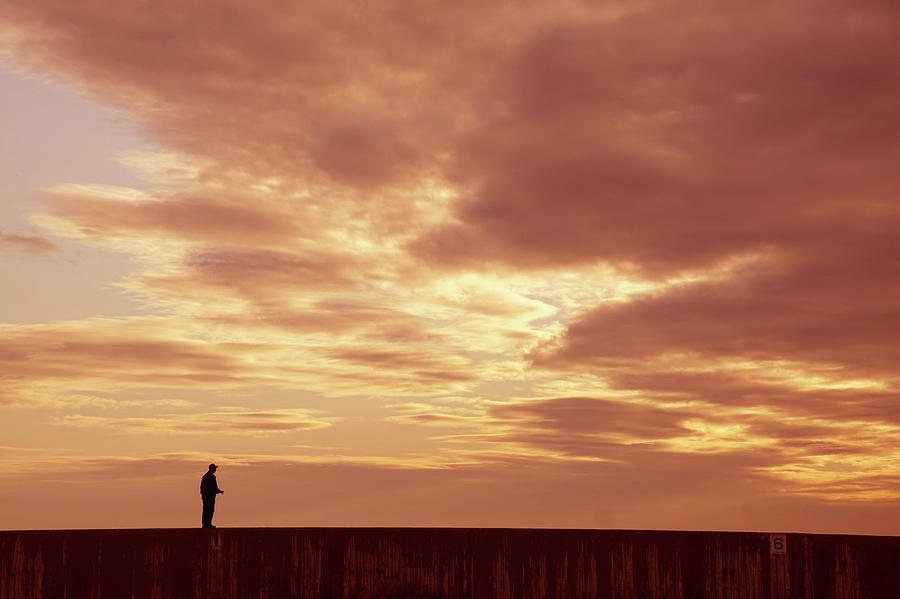 Silhouette of beach walkers at sunset Photograph by Steve Estvanik