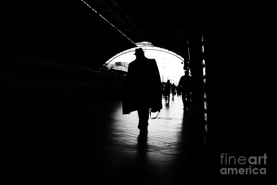 Silhouette of passengers in a train station. Photograph by Joaquin Corbalan