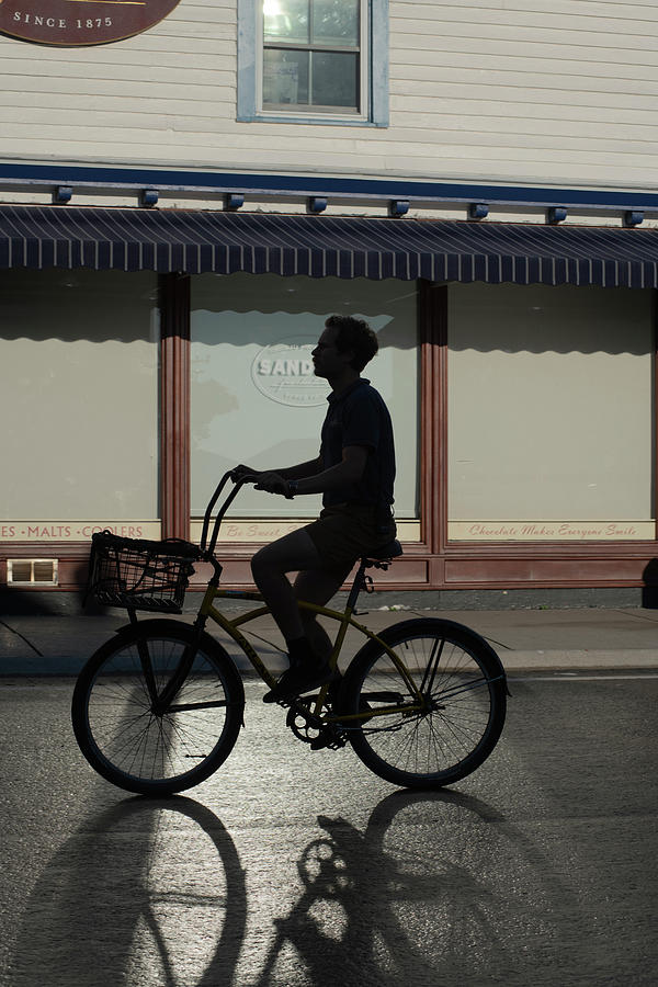 Silhouette Young  Man On Bike In Front Of Store With Shadow Photograph by Dan Friend
