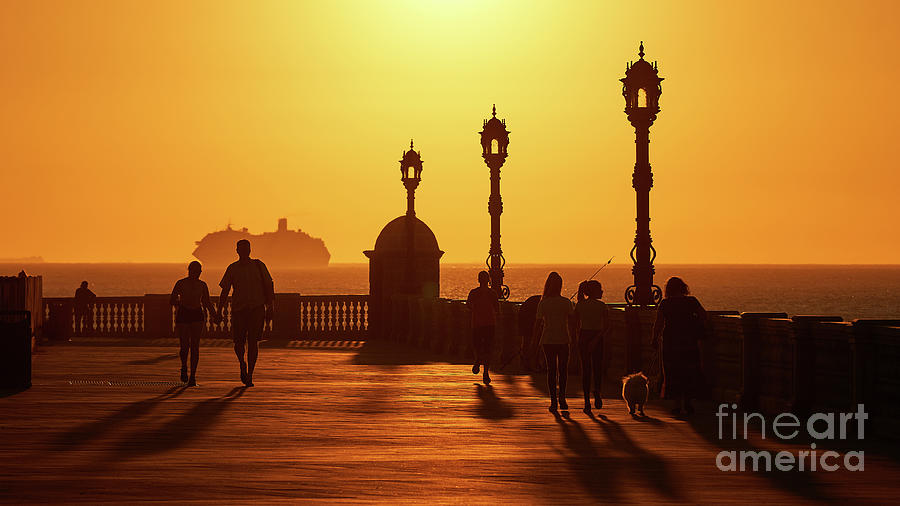 Silhouetted People Walking on Boardwalk with Cruiser at Sunset by Pablo Avanzini Silhouetted People Walking on Boardwalk with Cruiser at Sunset by Pablo Avanzini