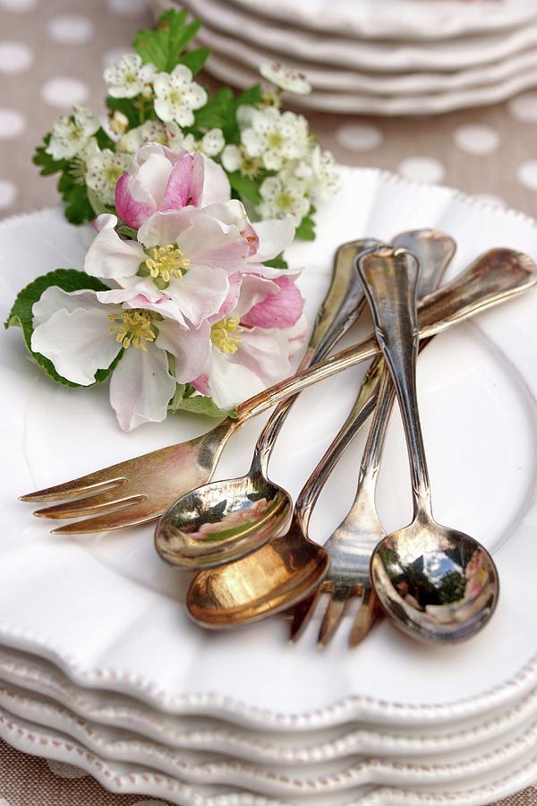 Silver Cutlery Of Flower Arrangement On Stacked Plates Photograph by Angelica Linnhoff