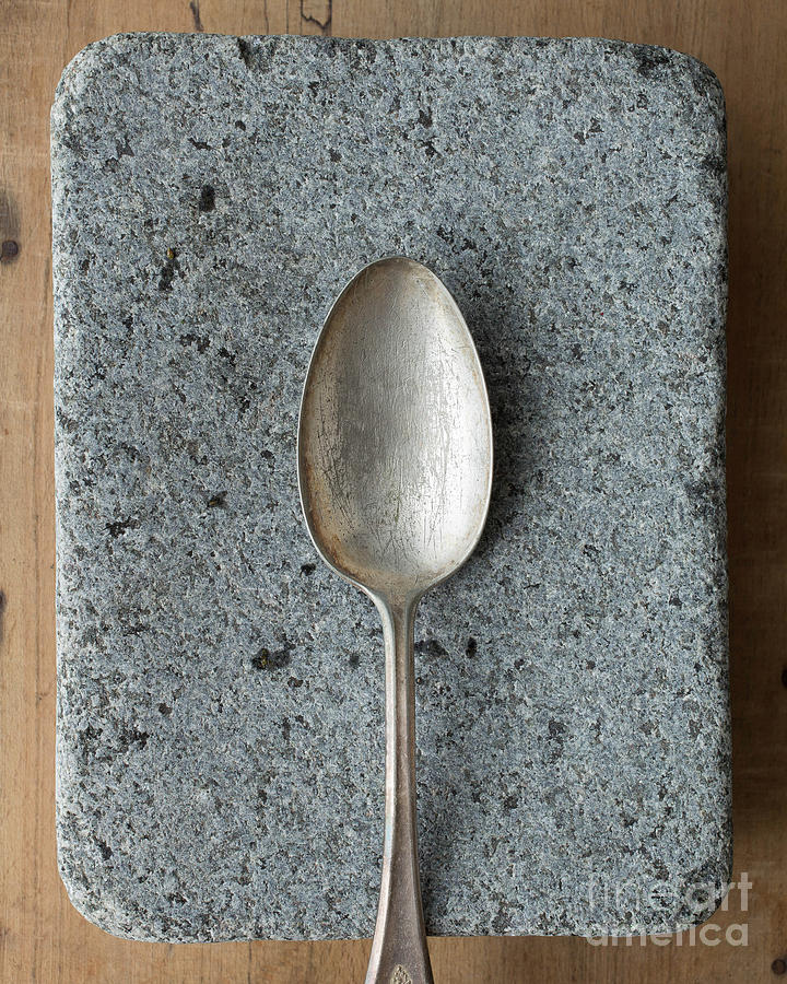 Silver spoon over granite and wood Photograph by Edward Fielding