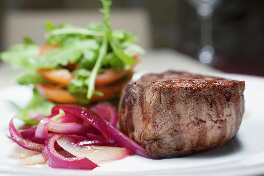 Sirloin Steak With Red Onions, Tomatoes And Rocket Leaves Photograph by Jan Prerovsky