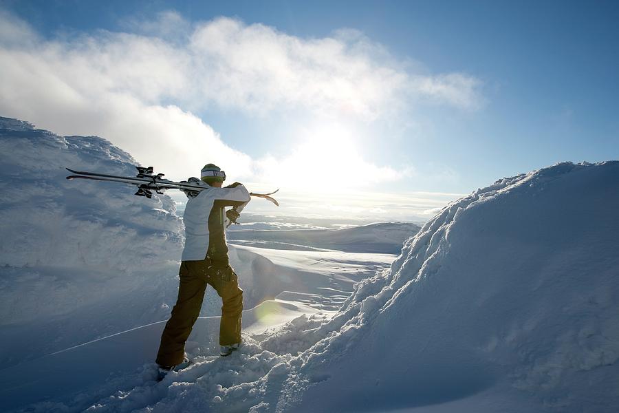 Skier Carrying Skies On The Shoulder Photograph by Henrik Trygg