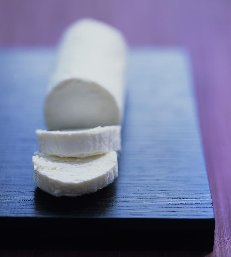 Cheese Photograph - Slice Of Goats Cheese With Goat Cheese Log by Clive Streeter
