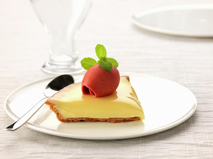 Slice Of Lemon Curd Pie Topped With A Twirl Of Raspberry Sorbet Photograph by Gelberger