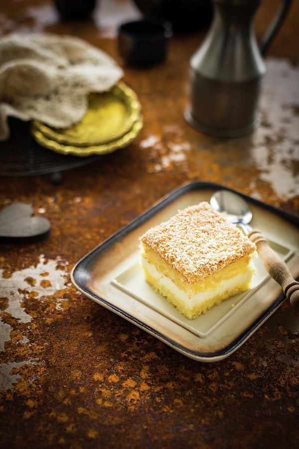 Slice Of The Sponge Cake With Lemon Cheese Cream And Coconut Shreds Photograph by Osmykolorteczy