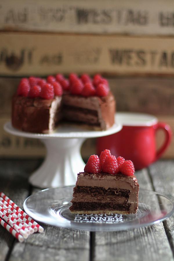 Sliced Chocolate Cake With Raspberries On A Cake Stand And Plate Photograph by Sylvia E.k Photography