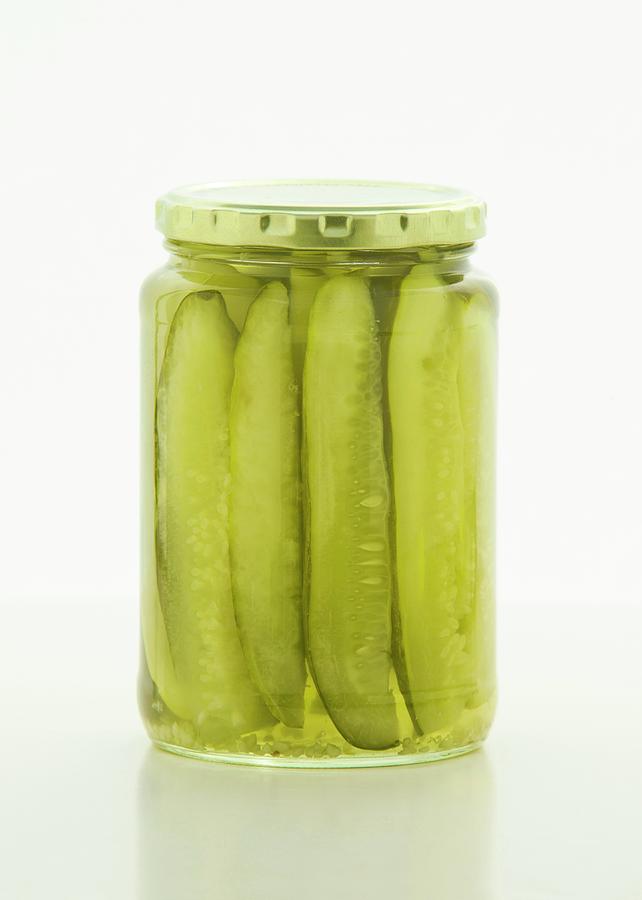 Sliced Gherkins In A Screw-top Jar On A White Surface Photograph by William Boch