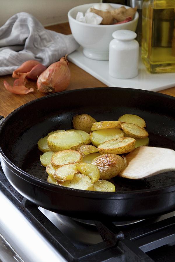 Sliced Potatoes Being Fried In A Pan Photograph by Catja Vedder