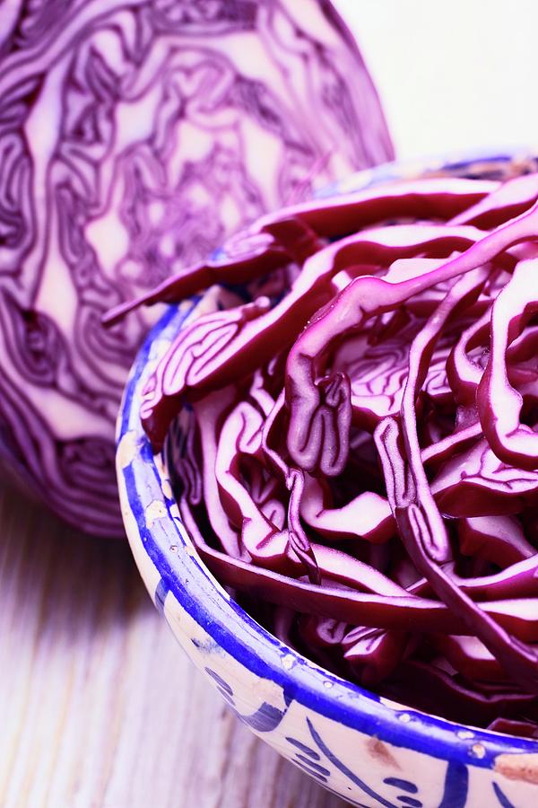 Sliced Red Cabbage In A Bowl In Front Of Half A Red Cabbage Photograph