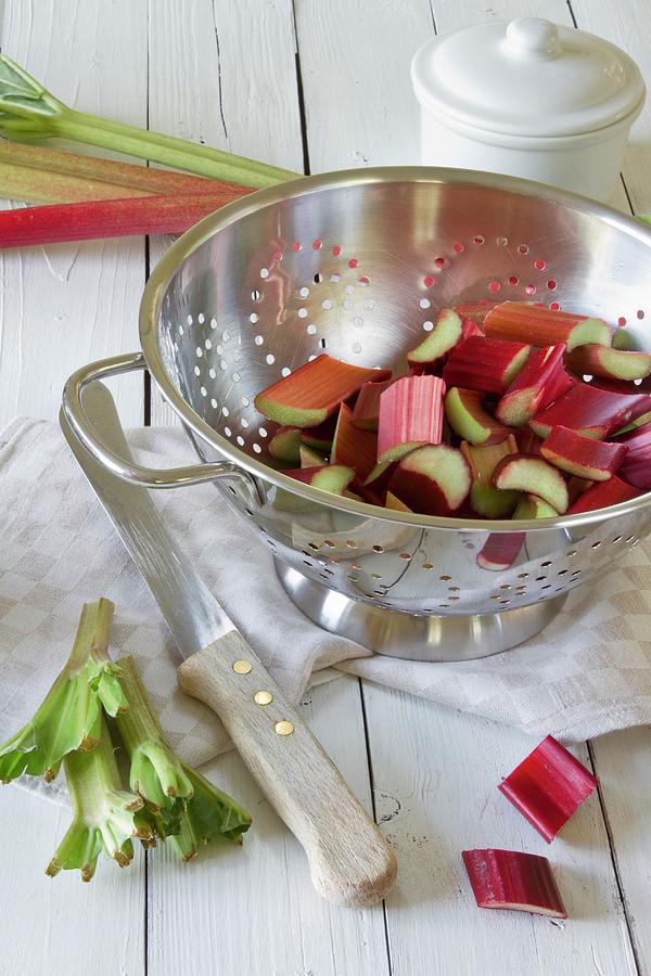 Sliced Rhubarb In A Silver Colander On A Wooden Table Photograph by Catja Vedder