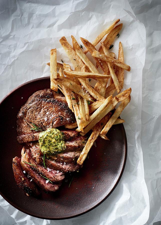 Sliced Ribeye Steak With Herb Butter And Thin French Fries Photograph by Great Stock!