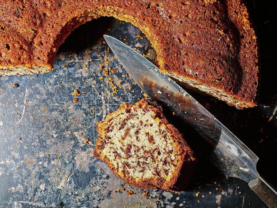 Sliced Rum And Nut Cake With A Knife On A Baking Tray Photograph by Foto4food