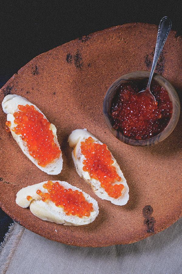 Slices Of Baguette Topped With Red Caviar On An Old Terracotta Platter Photograph by Natasha Breen