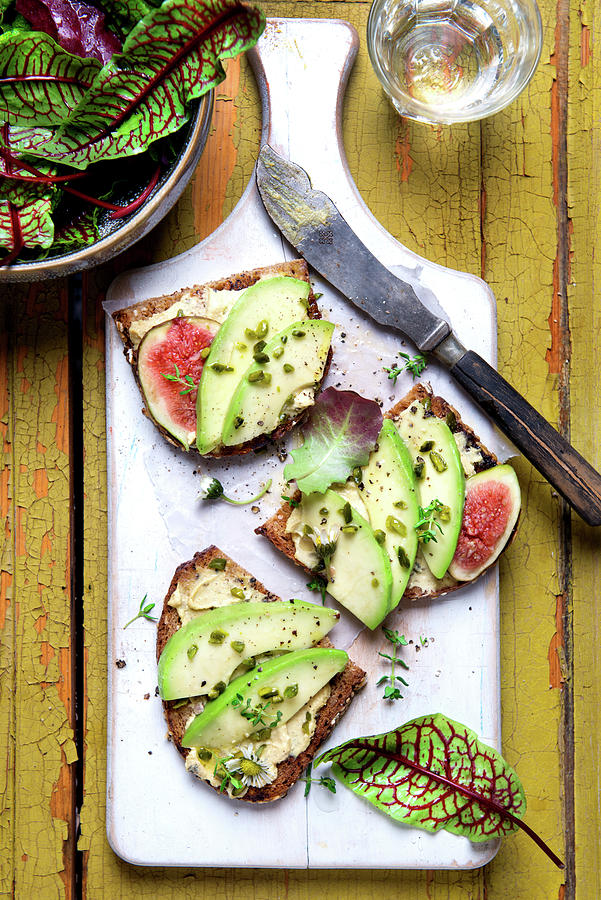 Slices Of Bread Topped With Avocado, Figs, Pistachio Nuts, Thyme And Wild Herb Salad Photograph by Angelika Grossmann