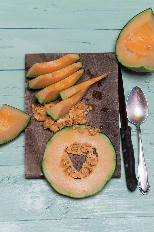 Slices Of Cantaloupe Melon On A Wooden Board Photograph by Angelika Grossmann