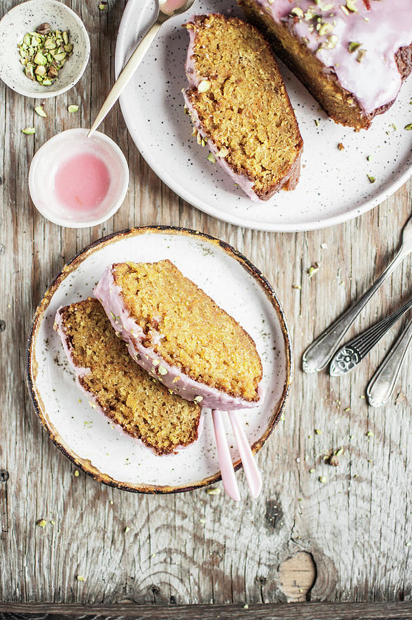 Slices Of Carrot Cake Topped With Pink Icing And Chopped Pistachios Photograph by Kachel Katarzyna