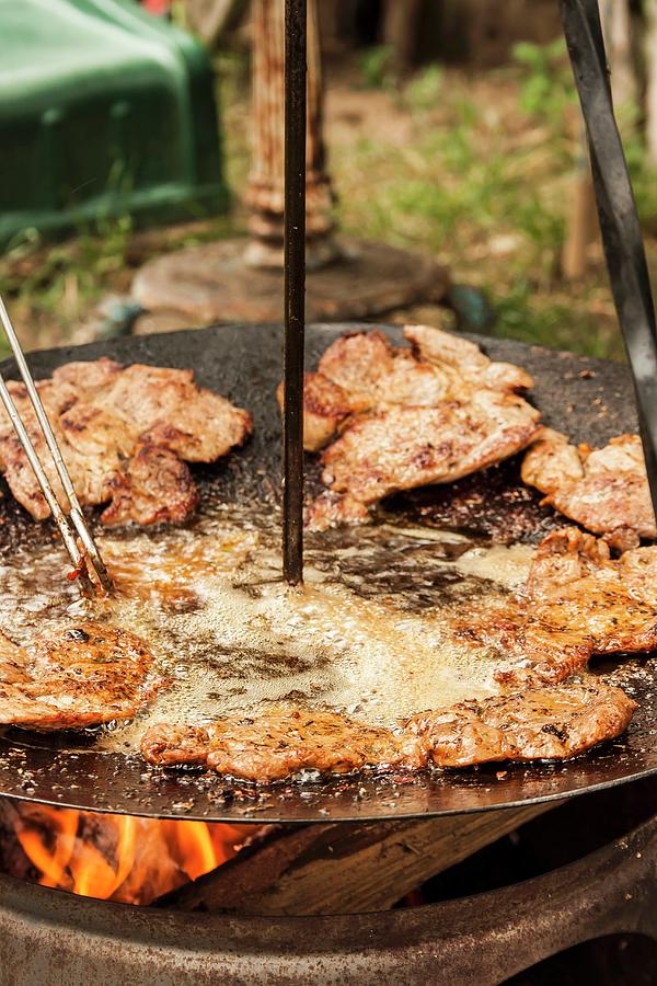 Slices Of Meat Being Fried In Oil In A Rustic Pan Photograph by Adel Bekefi