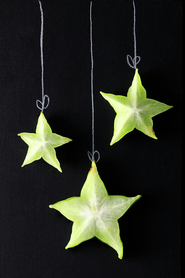 Slices Of Starfruit Arranged On A Blackboard To Look Like Christmas Decorations Photograph by Mona Binner Photographie