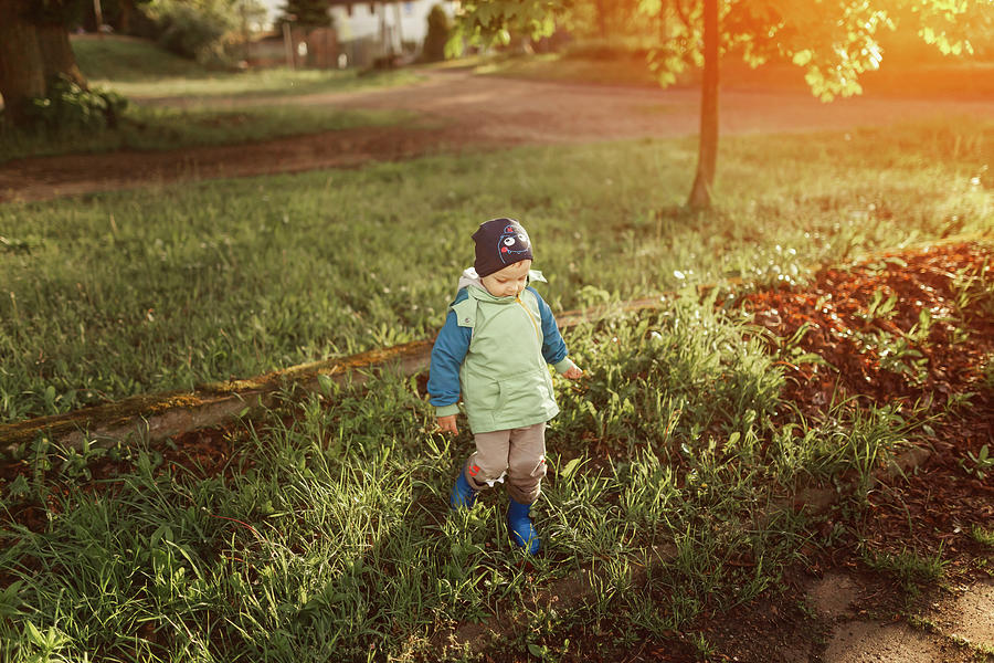 Small Boy Walking On Grass In Park Wearing Blue Wellingtons Photograph ...