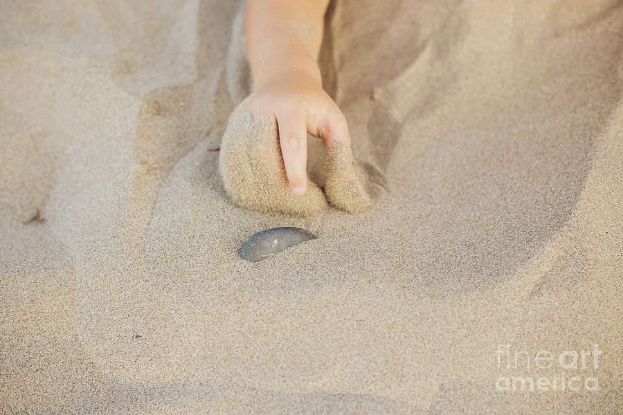 Small childs hand pointing a stone with his finger in the sand of the beach Photograph by Joaquin Corbalan