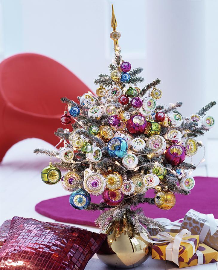 Small Christmas Tree Lavishly Decorated With Colourful Baubles Standing In Gold Vase Photograph by Matteo Manduzio