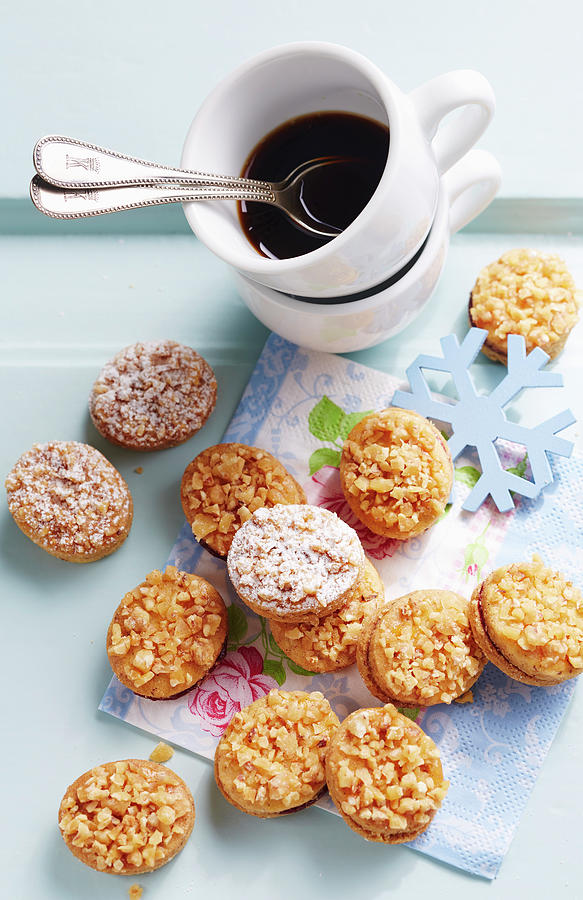 Small Crunchy Cookies Filled With Elderberry Jam, Served With A Cup Of Coffee Photograph by Teubner Foodfoto