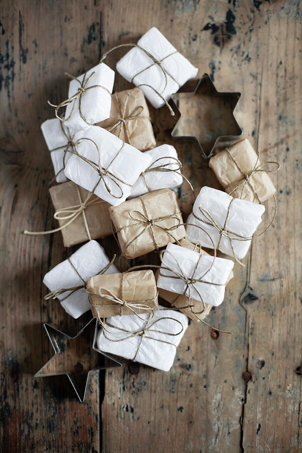 Small Gifts Wrapped In White And Pale Brown And Star-shaped Pastry Cutters Photograph by Alicja Koll