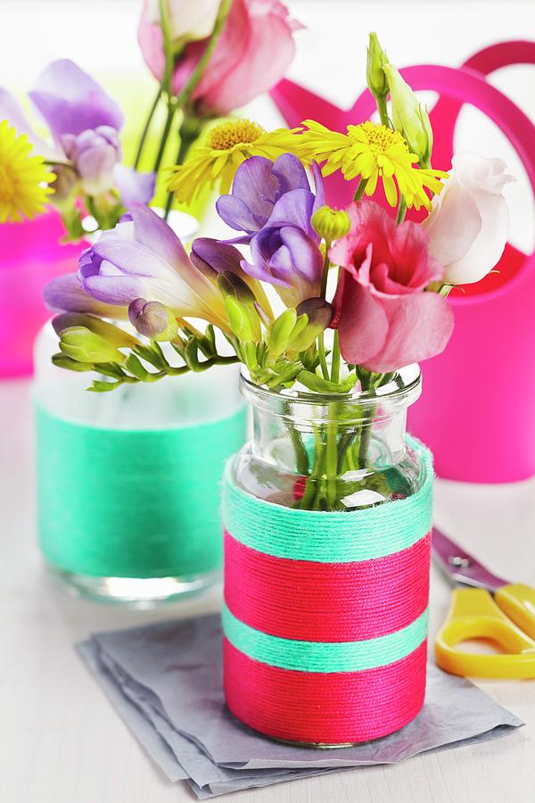 Small Glass Bottles Wrapped In Colourful Woollen Yarn Used As Vases Photograph by Franziska Taube