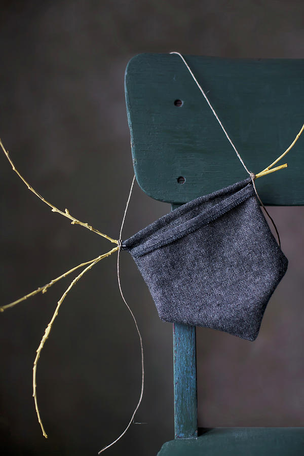 Small Hand-sewn Bag Made From Dark Fabric On Chair Backrest Photograph by Alicja Koll