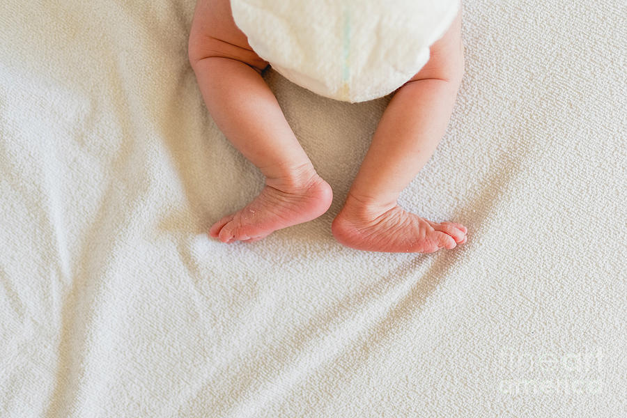 Small legs and feet of newborn baby on his bed. Photograph by Joaquin Corbalan