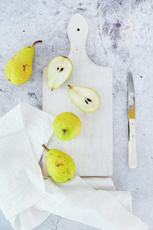 Small Pears On White Cutting Board Photograph by Claudia Gargioni