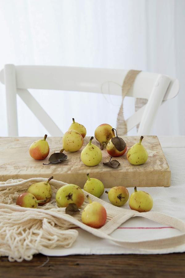 Small Pears With Leaves On A Wooden Chopping Board Photograph by Patricia Miceli